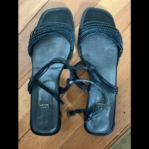 Stuart Weitzman black sandals with a low heel.